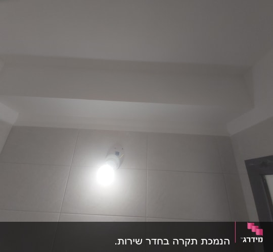 תקרה מגבס עם תאורה על קיר אריחים